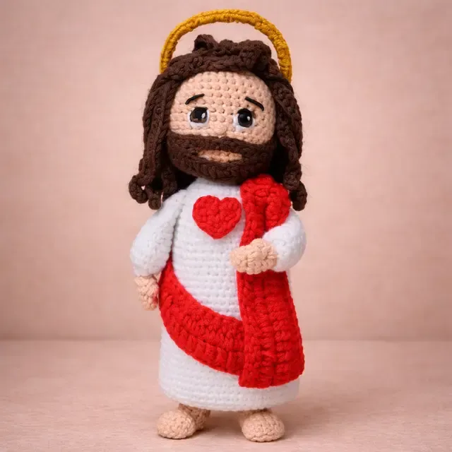 Jesus amigurumi com halo dourado, túnica branca e coração vermelho